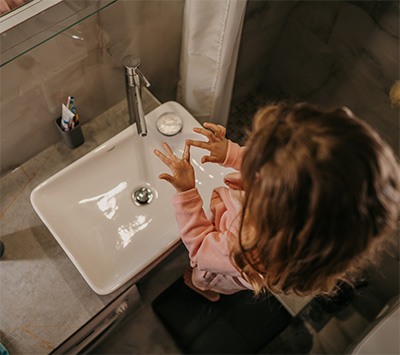 little girl dropped something down the sink drain